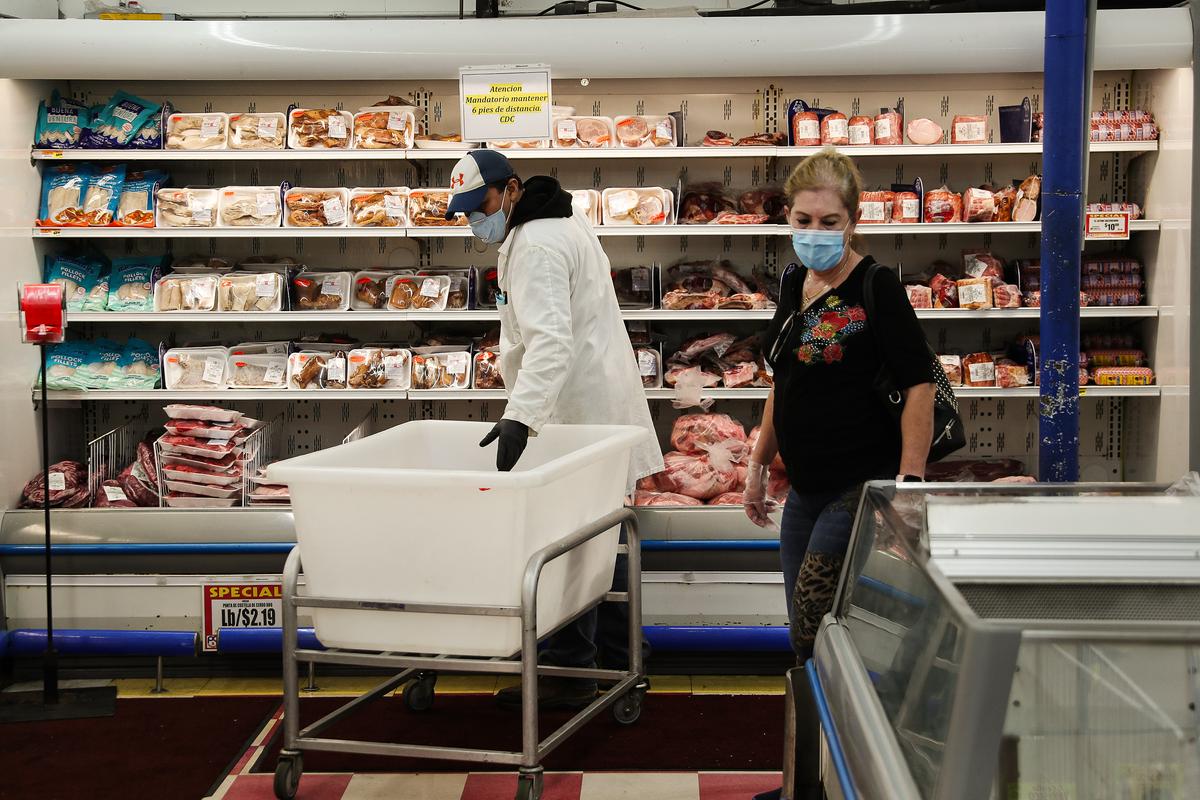 Wilson Castro restocks the shelves in the meat department at the Presidente Supermarket in Miami on April 13, 2020. (Joe Raedle/Getty Images)