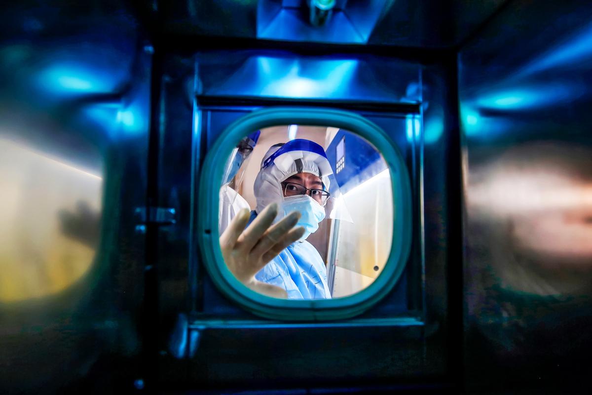 A medical staff member gestures inside an isolation ward at a Red Cross hospital in Wuhan in China's central Hubei Province on March 10, 2020. Chinese leader Xi Jinping said on March 10 that Wuhan has turned the tide against the deadly coronavirus outbreak. (STR/AFP via Getty Images)
