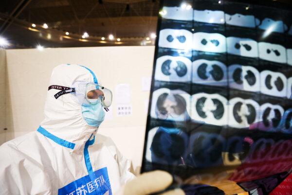 A doctor looks at a patient's CT scan at a temporary hospital set up for COVID-19 patients in a sports stadium in Wuhan, in China's Hubei Province on March 5, 2020. (STR/AFP via Getty Images)