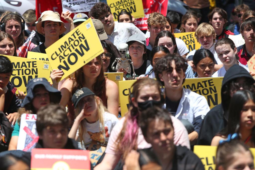Young climate activists sit outside the office of Tanya Plibersek, Minister for the Environment and Water in Sydney, Australia, on Nov. 17, 2023. (Lisa Maree Williams/Getty Images)