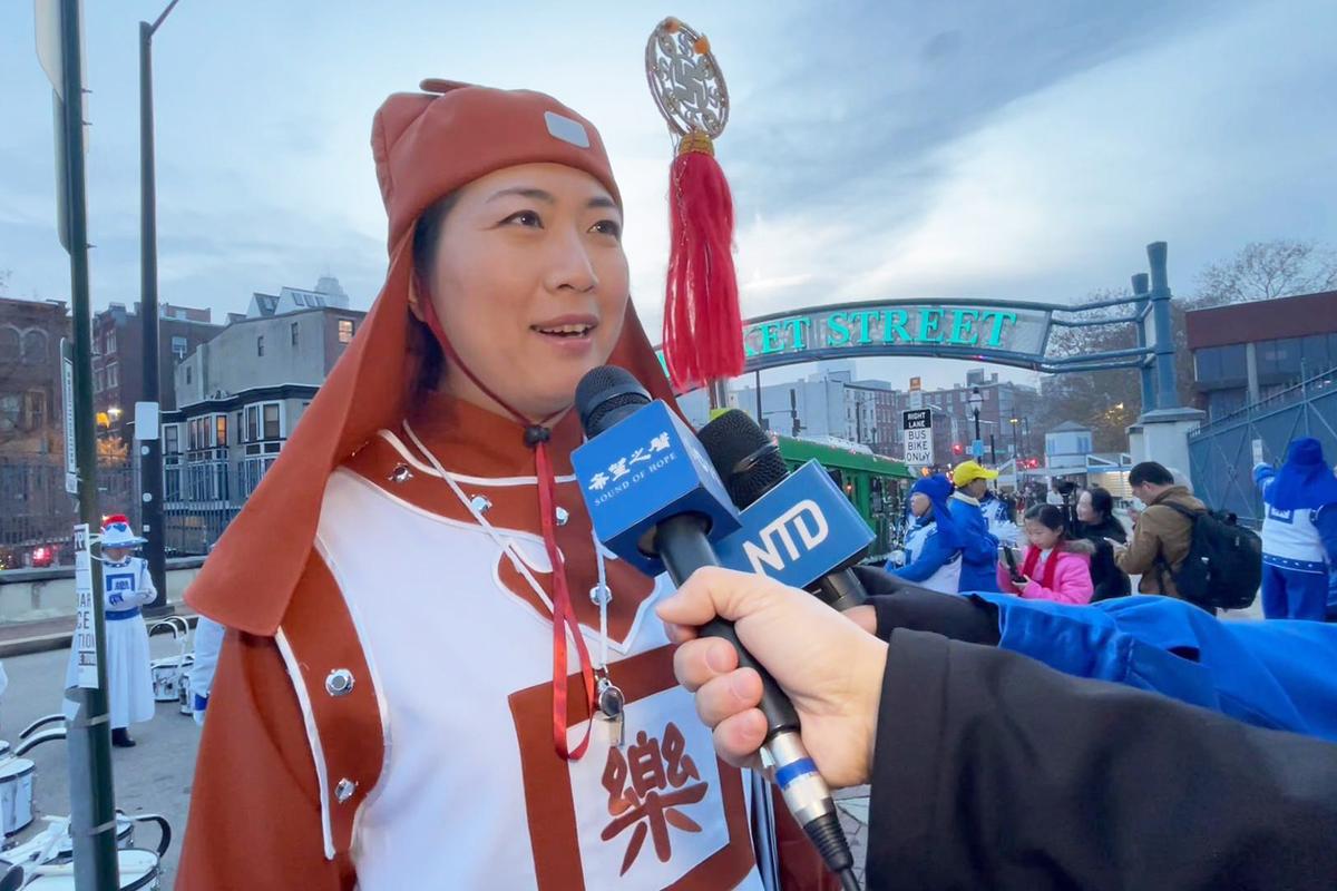 Michelle Mi, drum major of the New York Falun Dafa Tian Guo Marching Band, shares her views on the celebration just before the Philadelphia holiday parade on Dec. 2, 2023. (Frank Liang/The Epoch Times)