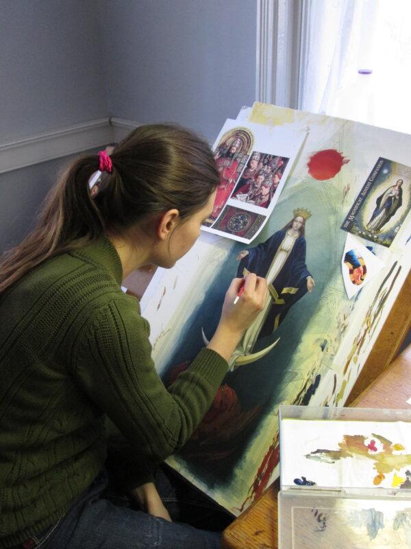 Illustrator Bernadette Carstensen paints Mary, the immaculate Virgin, as the centerpiece of her triptych “St. John’s Revelation.” She used Northern Renaissance references for the work, especially Jan van Eyck’s “Ghent Altarpiece” as seen on the left of her easel. (Courtesy of Bernadette Carstensen)