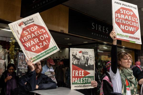 Pro-Palestinian protesters hold signs outside the office of federal Member for Wills Peter Khalil in Melbourne, Australia, on Dec. 2, 2023. (Diego Fedele/Getty Images)