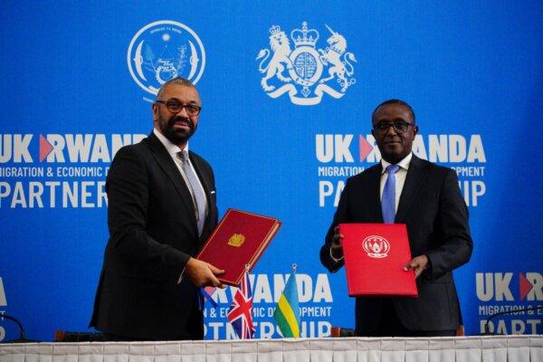 British Home Secretary James Cleverly (L) and Rwanda's foreign minister Vincent Biruta (R) pose for the cameras after signing a treaty in Kigali, Rwanda, on Dec. 5, 2023. (PA)