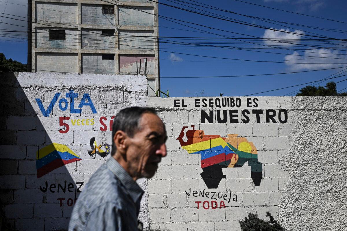 A man walks by a mural campaigning for a referendum asking Venezuelans to consider annexing the Guyana-administered region of Essequibo in Caracas, Venezuela, on Nov. 28, 2023. (Federico Parra/AFP via Getty Images)