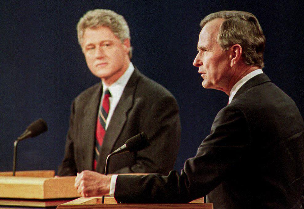 President George Bush (R) answers questions as Democratic presidential candidate Bill Clinton (L) listens on Oct. 11, 1992, in St. Louis, Mo. (Eugene Garcia/AFP via Getty Images)