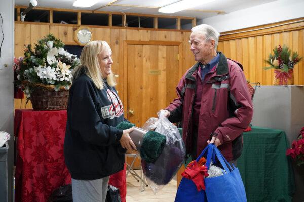 A local resident drops off donations at the Tri-State Interfaith Council warming center in Port Jervis, N.Y., on Dec. 1, 2023. (Cara Ding/The Epoch Times)