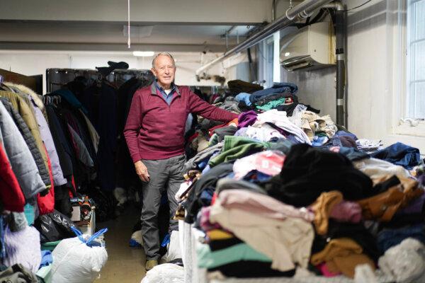 Jack Austin stands next to donated clothes at the Tri-State Interfaith Council warming center in Port Jervis, N.Y., on Dec. 1, 2023. (Cara Ding/The Epoch Times)