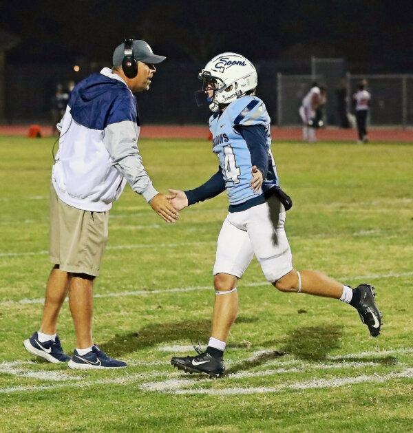 Mayfair High School football coach Derek Bedell greets a player in a recent football game. (Courtesy of Ted Meyers)
