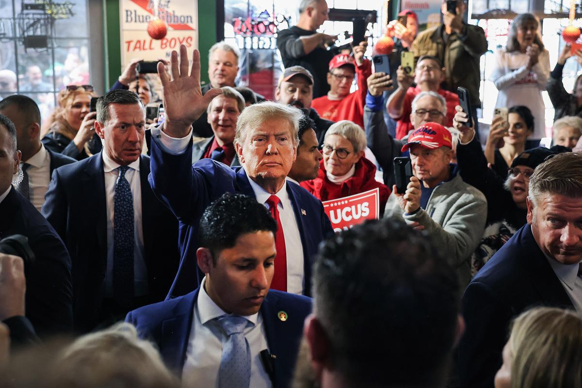 Republican presidential candidate former President Donald Trump greets guests as he arrives at a campaign event at the Whiskey River bar in Ankeny, Iowa, on Dec. 2, 2023. (Scott Olson/Getty Images)