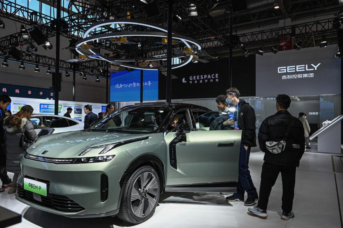 People try an electric vehicle at Geely's booth during the China International Supply Chain Expo (CISCE) in Beijing on Dec. 1, 2023. (Jade Gao /AFP via Getty Images)