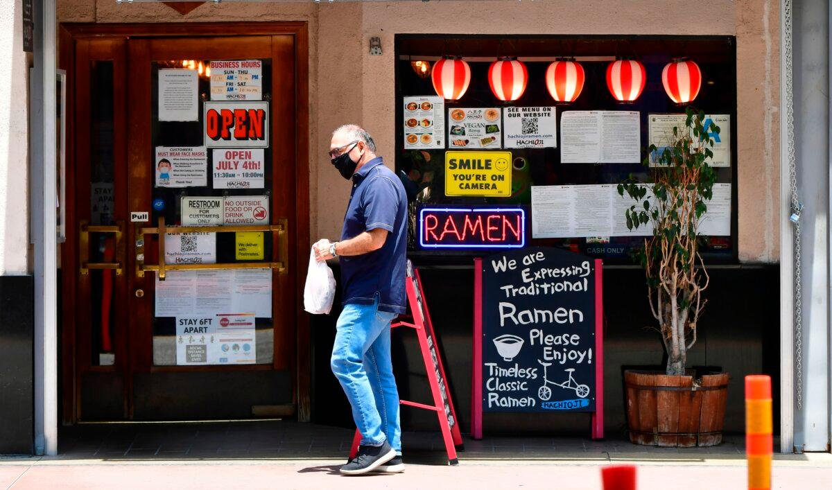 A man wearing a facemask walks past a Ramen restaurant in Los Angeles, California, on July 1, 2020. (Frederic J. Brown/AFP via Getty Images)