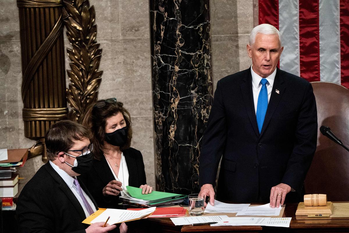  TOPSHOT - Vice President Mike Pence presides over a Joint session of Congress to certify the 2020 Electoral College results after supporters of President Donald Trump stormed the Capitol earlier in the day on Capitol Hill in Washington, DC on January 6, 2021. - Members of Congress returned to the House Chamber after being evacuated when protesters stormed the Capitol and disrupted a joint session to ratify President-elect Joe Biden's 306-232 Electoral College win over President Donald Trump. (Photo by Erin Schaff / POOL / AFP) (Photo by ERIN SCHAFF/POOL/AFP via Getty Images)