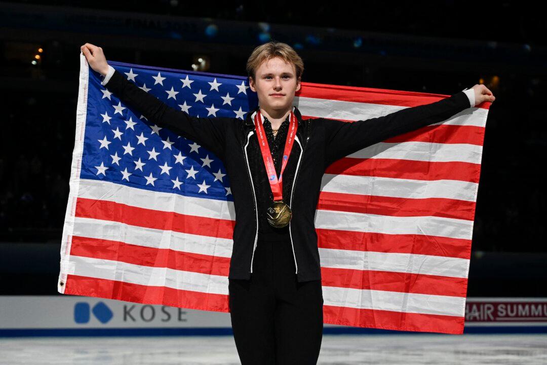 Gold medallist Ilia Malinin of the United States poses with the country's national flag at the medal ceremony for men's free skating event during the ISU Grand Prix of Figure Skating Final in Beijing on Dec. 9, 2023. (Wang Zhao/AFP via Getty Images)