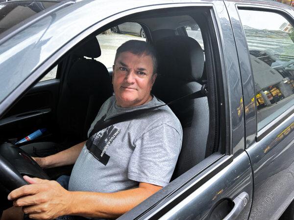 Carlos Bastino, 58, in the car he uses for work as a driver in Buenos Aires, Argentina, on Dec. 9, 2023. (Marcos Schotgues/The Epoch Times)