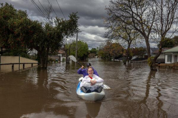 Two residents canoe down a flooded street in the suburb of Maribyrnong in Victoria, Australia, on Oct. 14, 2022. (Asanka Ratnayake/Getty Images)