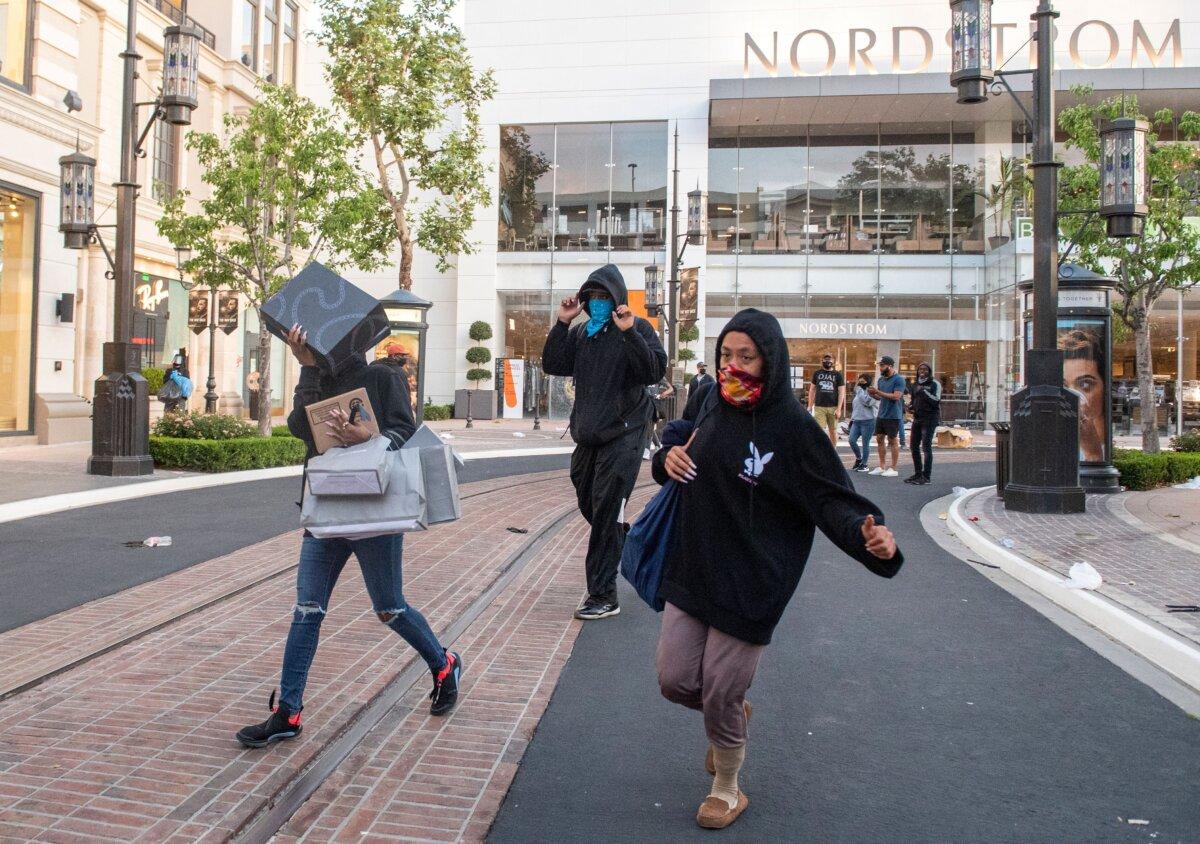 People are seen looting stores at the Grove shopping center in the Fairfax District of Los Angeles, in a file photo. (Valerie Macon/AFP via Getty Images)