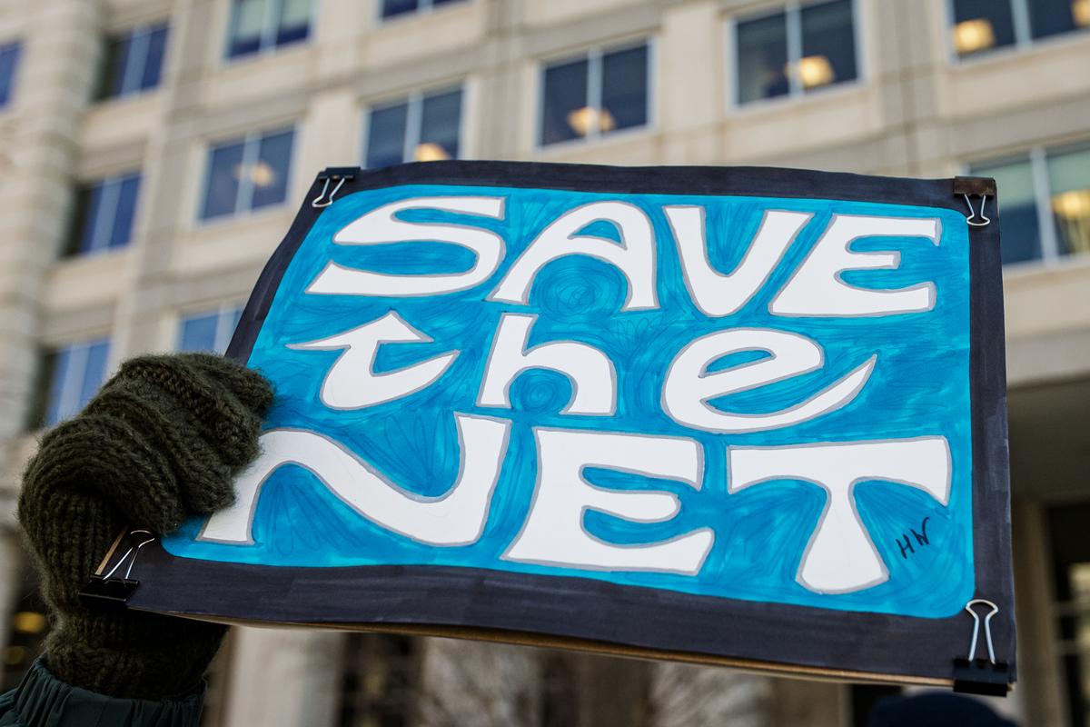  A woman holds a 'Save the Net' protest sign during a demonstration against the proposed repeal of net neutrality outside the Federal Communications Commission headquarters in Washington on Dec. 13, 2017. (Alex Edelman/AFP via Getty Images)