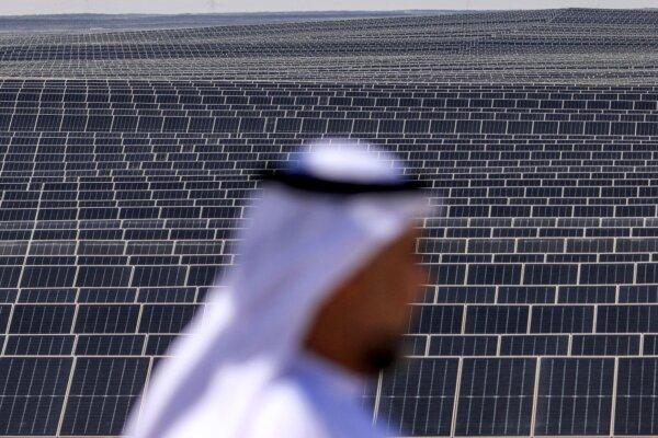 An Emirati man stands in front of photovoltaic panels at a project south of Abu Dhabi, United Arab Emirates, on Nov. 13, 2023. (Karim Sahib/AFP via Getty Images)