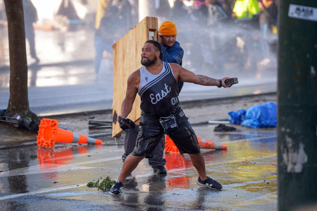 People face off with police near Parliament as police moved in to clear protesters in Wellington, New Zealand on March 2, 2022. (Dave Lintott/AFP via Getty Images)