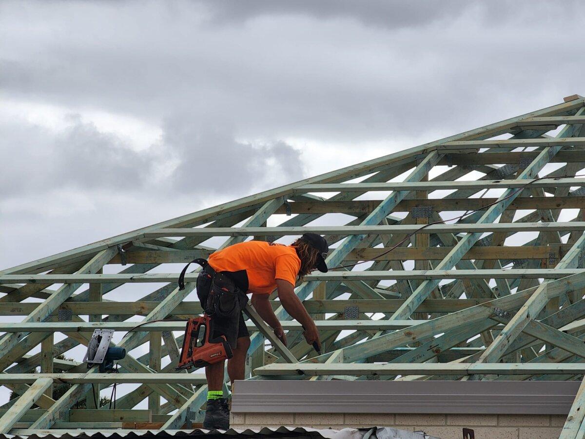 A man works on the roof of a new home in Albany, Western Australia, on Dec. 14, 2023. (Susan Mortimer/The Epoch Times)