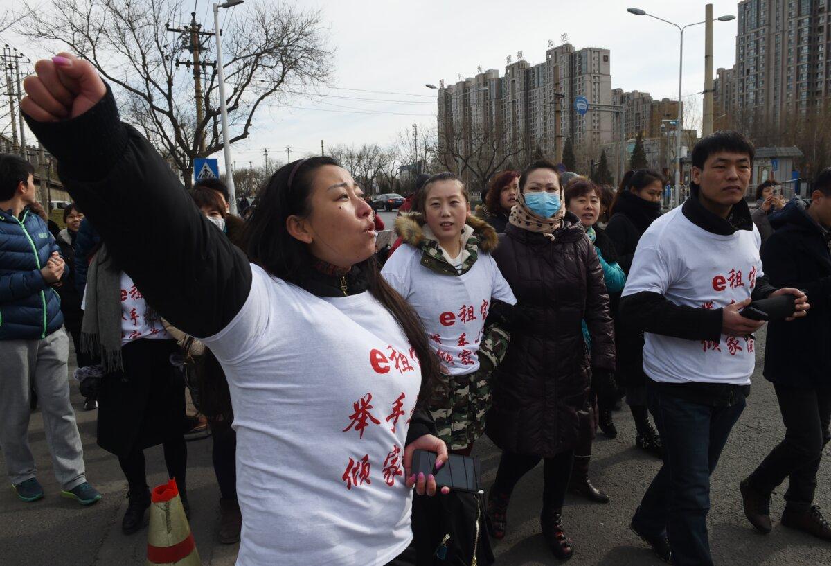 Investors in Chinese online peer-to-peer lender Ezubao chanting slogans during a protest in Beijing, on Feb. 4, 2016. (Greg Baker /AFP via Getty Images)