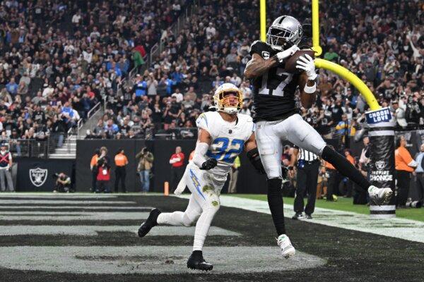 Wide receiver Davante Adams (17) of the Las Vegas Raiders catches a touchdown pass in front of safety Alohi Gilman (32) of the Los Angeles Chargers during third quarter in Las Vegas on Dec. 14, 2023. (Candice Ward/Getty Images)