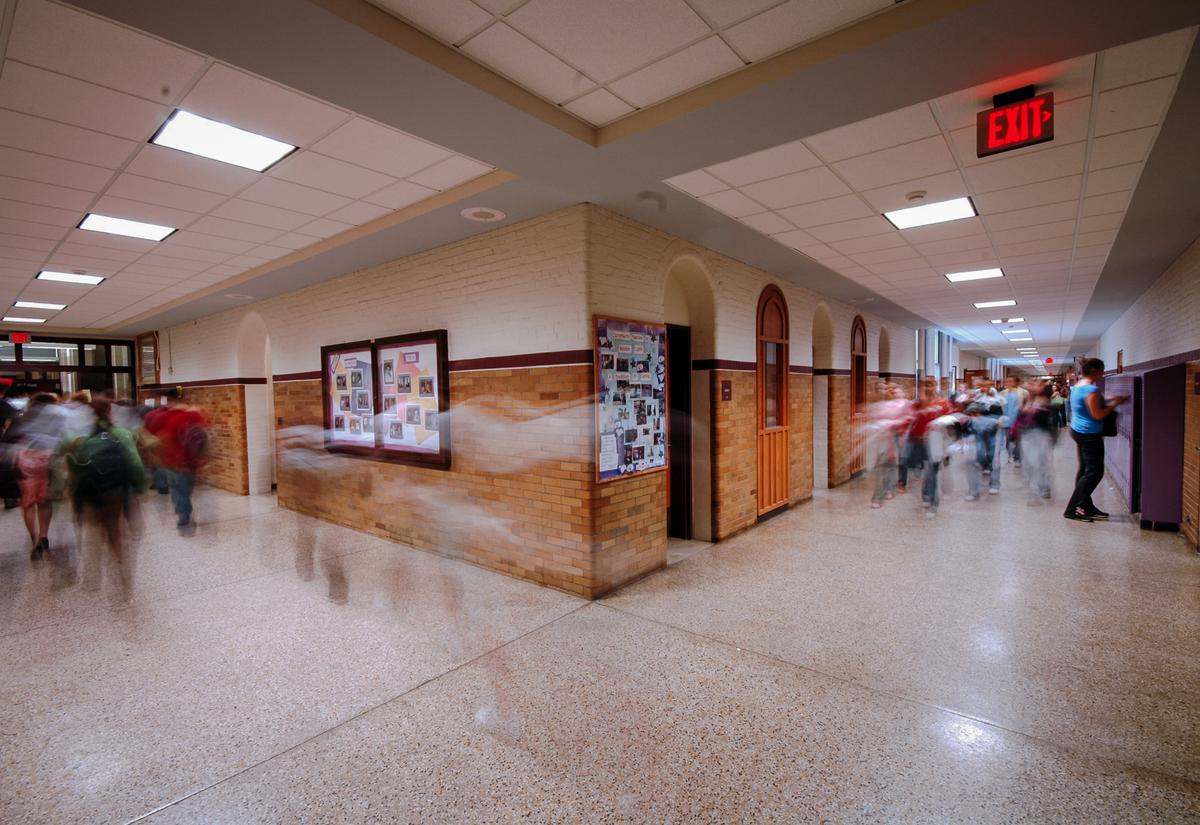 Students walk between classes in a hallway at a school. (Matty Symons/Shutterstock)