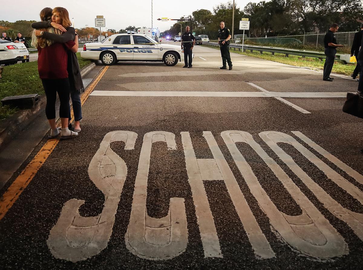 Women hug at a police checkpoint near the Marjory Stoneman Douglas High School, where 17 people were killed the day before, in Parkland, Fla., on Feb. 15, 2018. (Mark Wilson/Getty Images)
