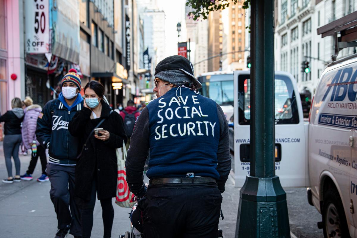 A man wearing a shirt with “Save Social Security” written on it walks along a street in New York City on Nov. 2, 2020. (Chung I Ho/The Epoch Times)