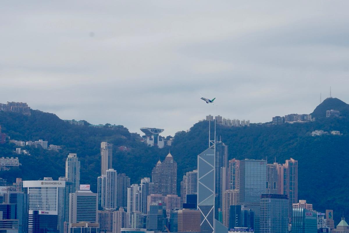 China’s C919 passenger plane flies over Victoria Harbor for a demonstration, on Dec. 16, 2023, in Hong Kong. (Yu Gang/The Epoch Times)