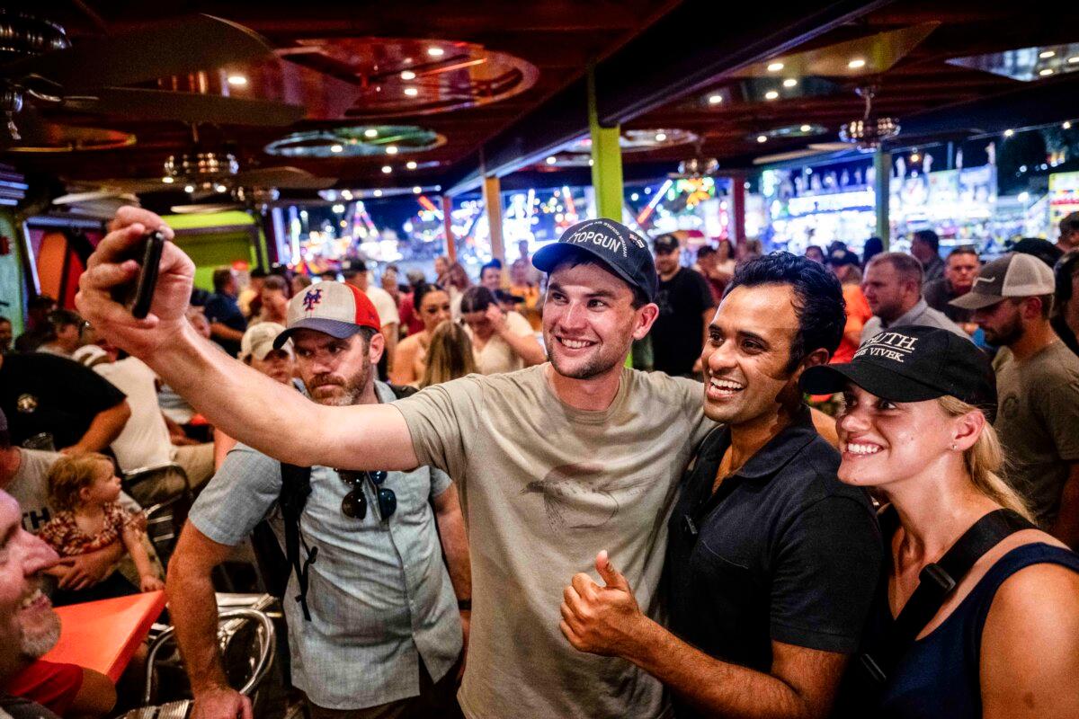 Republican presidential candidate businessman Vivek Ramaswamy (C) takes a selfie with supporters at Jalapeno Pete's Bar at the Iowa State Fair in Des Moines, Iowa, on Aug. 11, 2023. (Brandon Bell/Getty Images)