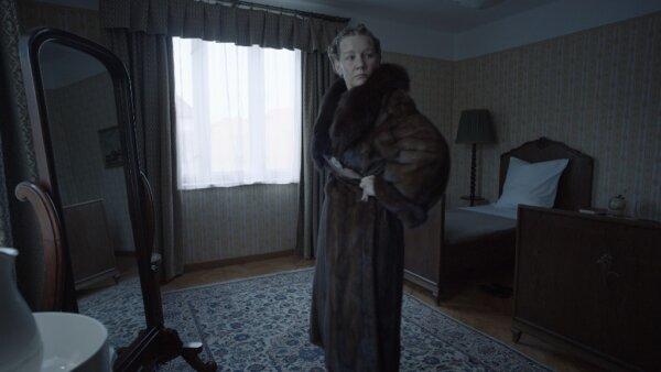 Hedwig Höss (Sandra Hüller) tries on a fur coat taken from Jews, in "The Zone of Interest." (A24)