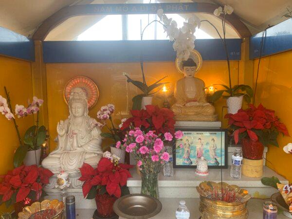 The original Buddha and Guan Yin statues with flowers, incense, candles, and water offerings on Dec. 5, 2023. (Helen Billings/The Epoch Times)