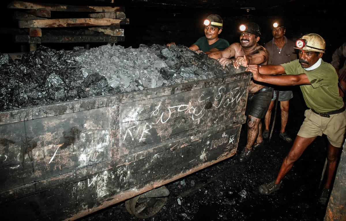 Coal miners push a trolley laden with coal inside an underground tunnel of a mine at Godavarikhani, some 150 miles east of Hyderabad, India, on July 27, 2007. (Noah Seelam/AFP via Getty Images)