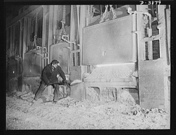 A step in the making of steel. A workman at an Eastern steel plant banks the doors of an open hearth furnace after the charge of steel. Circa 1941. (Farm Security Administration - Office of War Information Photograph Collection at Library of Congress)