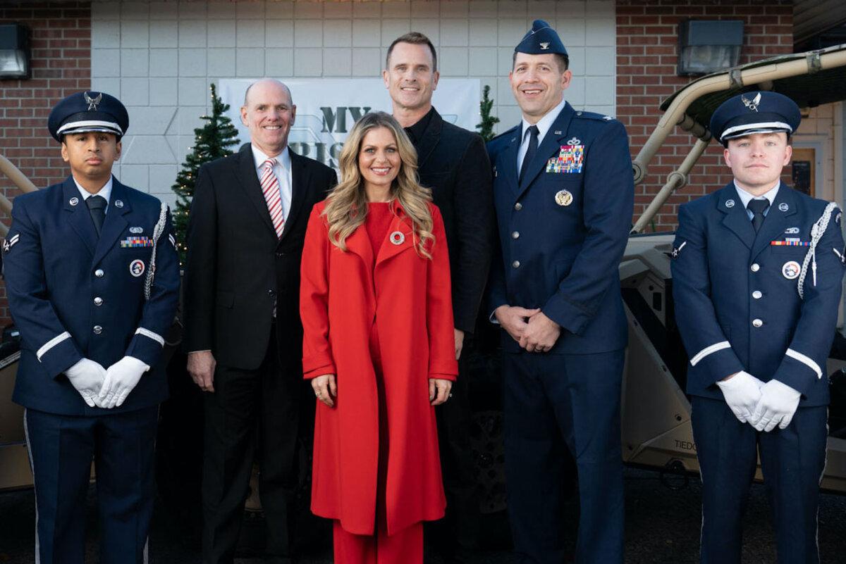 Bill Abbott, Candace Cameron Bure, Gabriel Hogan, and Col. Brandon Sokora pose for a photo with service members at the premiere of ‘My Christmas Hero’ in Joint Base Lewis McChord, Wash., on Nov. 15, 2023. (Suzi Pratt/Getty Images for Great American Family)