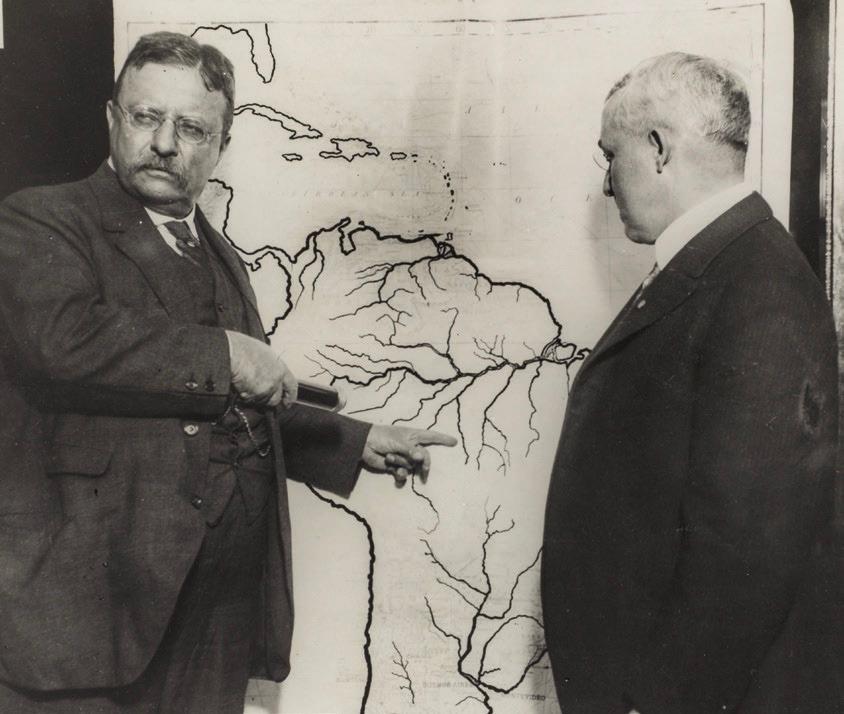 Roosevelt points at a map of the area explored during the Roosevelt– Rondon Scientific Expedition in Brazil, between 1913–1919. (Public Domain)