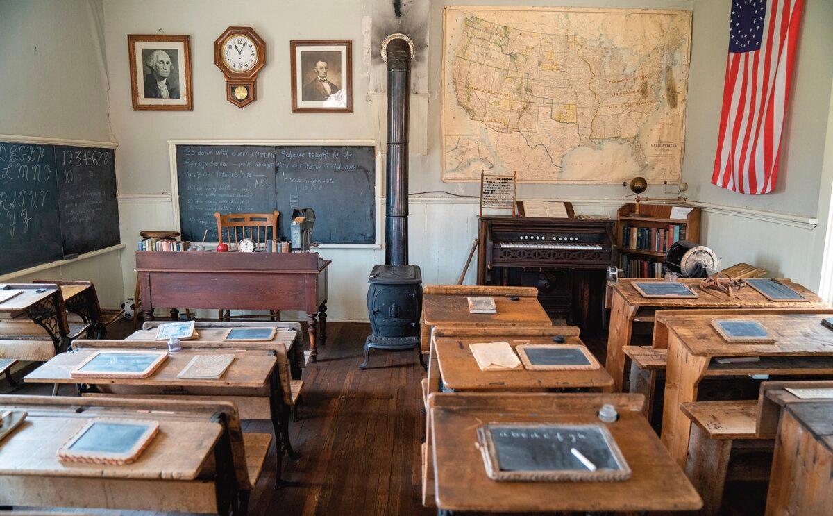 Interior of a one-room schoolhouse, with a potbelly stove, slate tablets, and blackboard, in South Park City, Colo. (melissamn/Shutterstock)