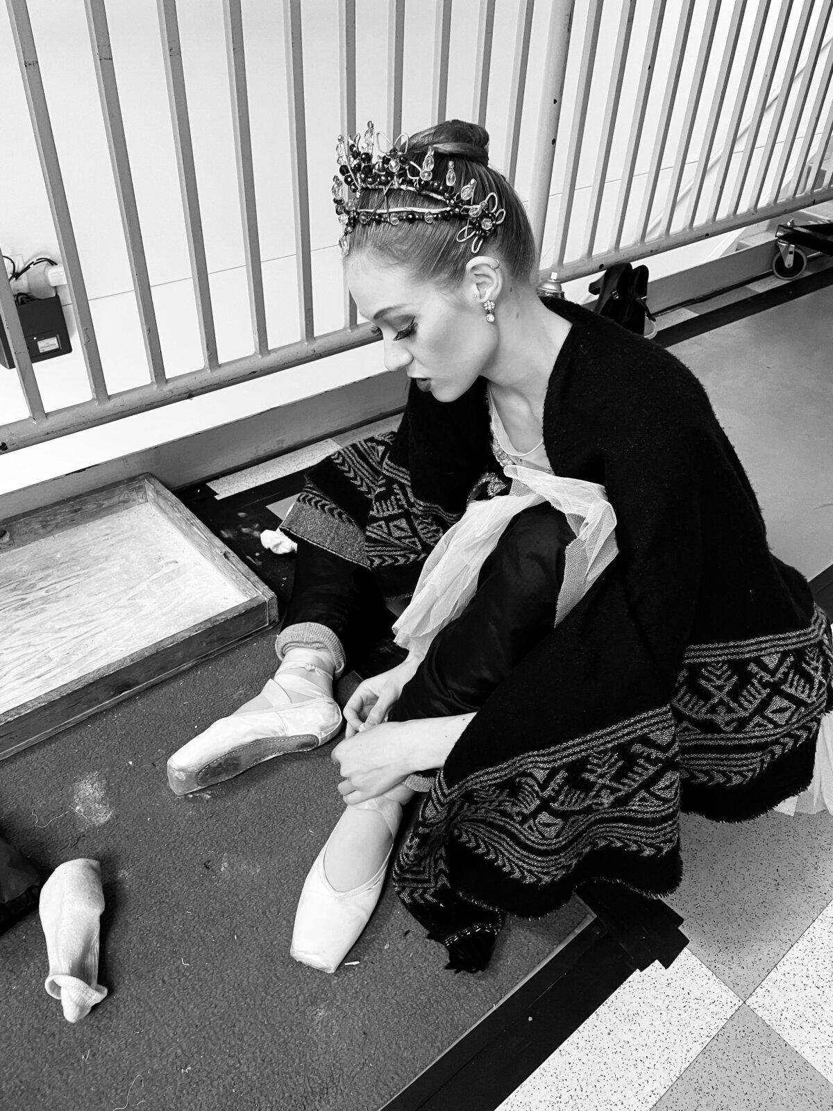 Ms. Nyman ties her pointe shoes before performing as the Sugar Plum Fairy in “The Nutcracker.” (Katelyn Rhodes)