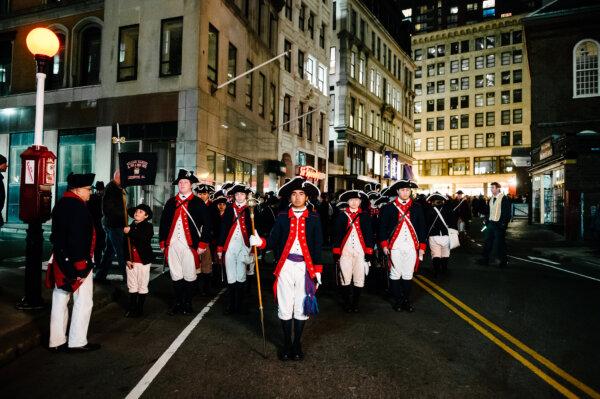 Colonial reenactors march through Downtown Boston toward the Boston Harbor as part of the Boston Tea Party 250th Anniversary celebration. (Courtesy of December 16.org)