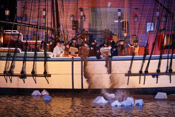 Reenactors dump the tea into the harbor in the finale of the Boston Tea Party 250th Anniversary celebration. (Courtesy of December 16.org)