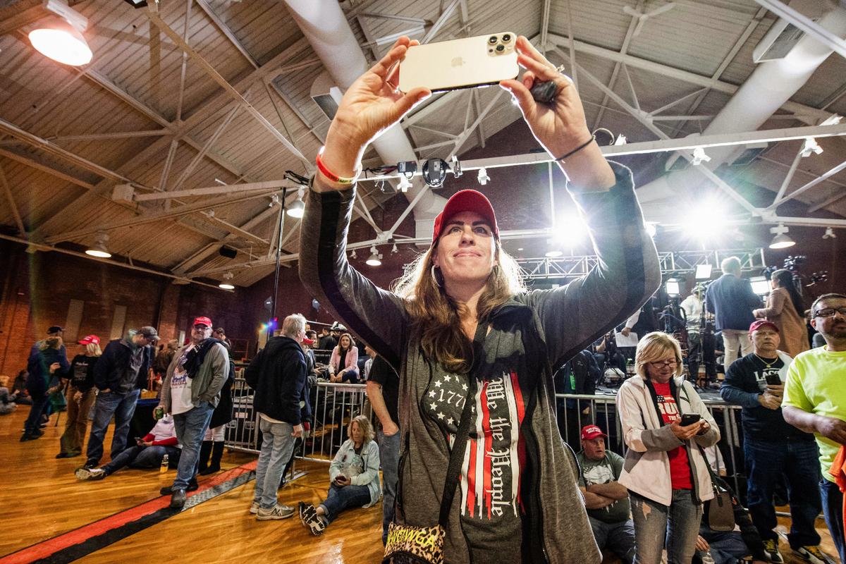 A woman takes a photo at a Make America Great Again Rally with former President Donald Trump, in Manchester, N.H., on April 27, 2023. (Joseph Prezioso/AFP via Getty Images)