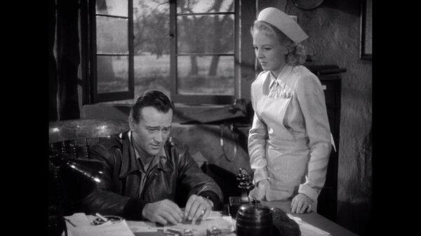 Capt. Jim “Pappy” Gordon (John Wayne) being consoled by his girlfriend “Brooke Elliott (Anna Lee), in “Flying Tigers.” (Republic Pictures)