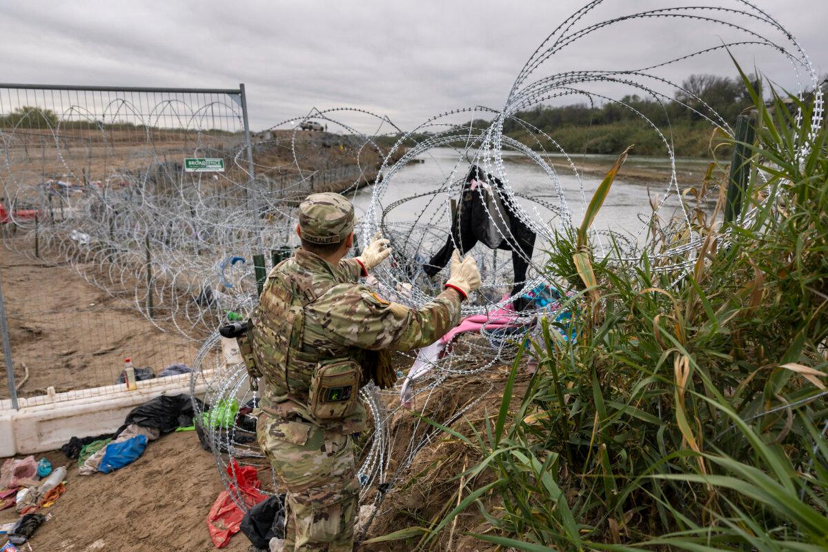 A Texas National Guard soldier installs additional razor wire at the U.S.-Mexico border in Eagle Pass, Texas on Dec. 20, 2023. (John Moore/Getty Images)