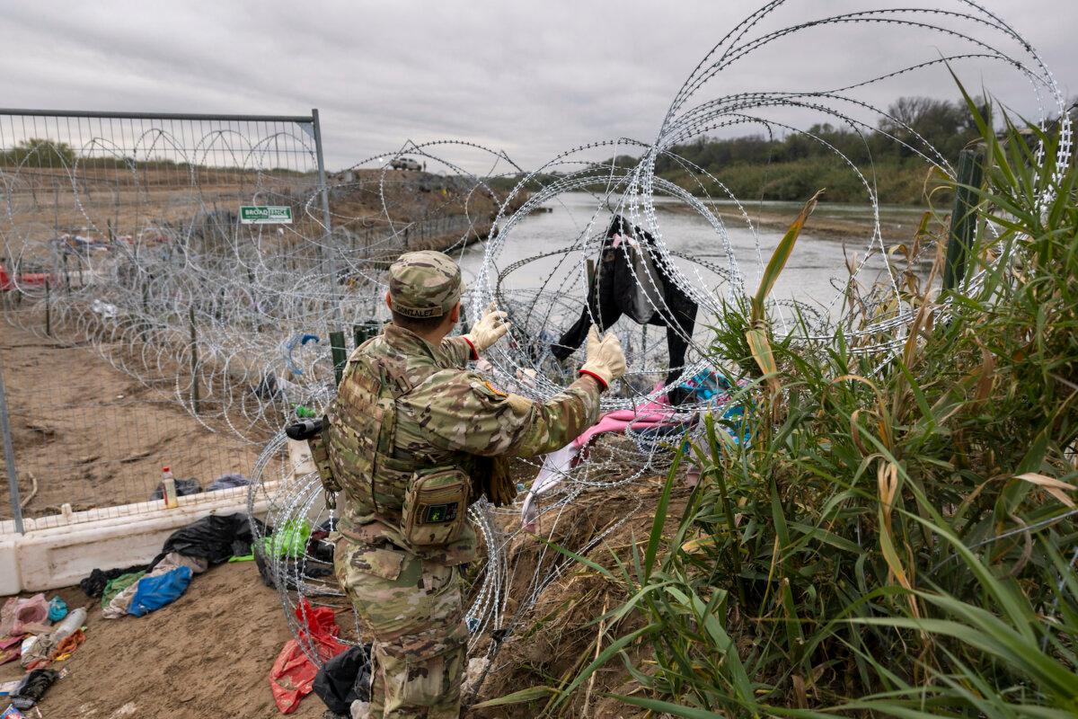 Elon Musk Says Biden Administration ‘Actively Aiding Illegal Immigration’ | USNN World News A Texas National Guard soldier installs additional razor wire at the U.S.-Mexico border in Eagle Pass, Texas on Dec. 20, 2023. (John Moore/Getty Images)
