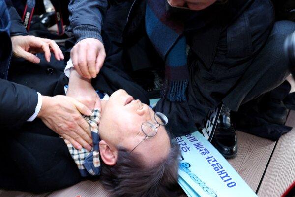 South Korea's opposition party leader Lee Jae-myung falls after being attacked by an unidentified man during his visit to Busan, South Korea, on Jan. 2, 2024. (Yonhap via Reuters)