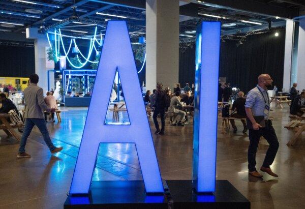 People walk past an AI sign at the All In artificial intelligence conference in Montreal on Sept. 28, 2023. (The Canadian Press/Ryan Remiorz)