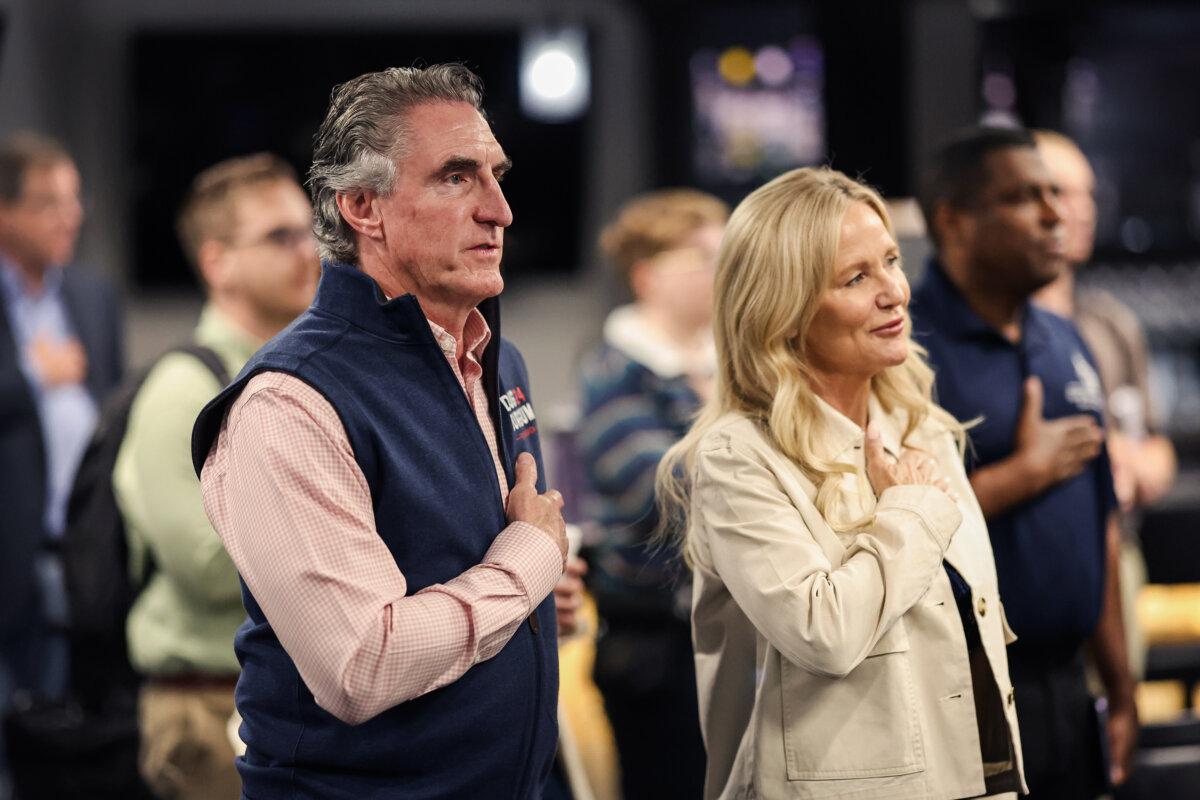 Republican presidential candidate North Dakota Gov. Doug Burgum and his wife Kathryn Burgum recite the pledge of allegiance during a campaign stop in Ankeny, Iowa, on June 9, 2023. (Scott Olson/Getty Images)