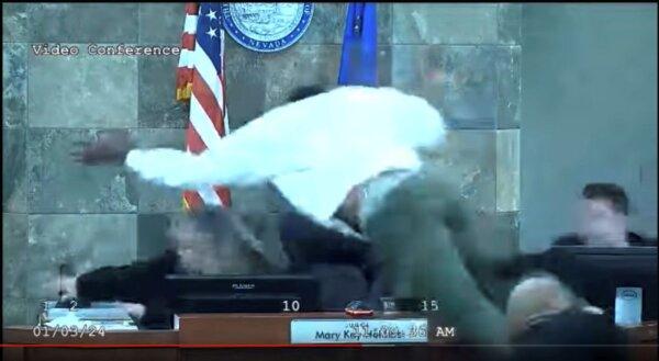 In this image from video, Deobra Redden is seen launching over the desk of Judge Mary Kay Holthus during his sentencing in a felony battery case in Las Vegas on Jan. 3, 2024. (Clark County District Court via AP)